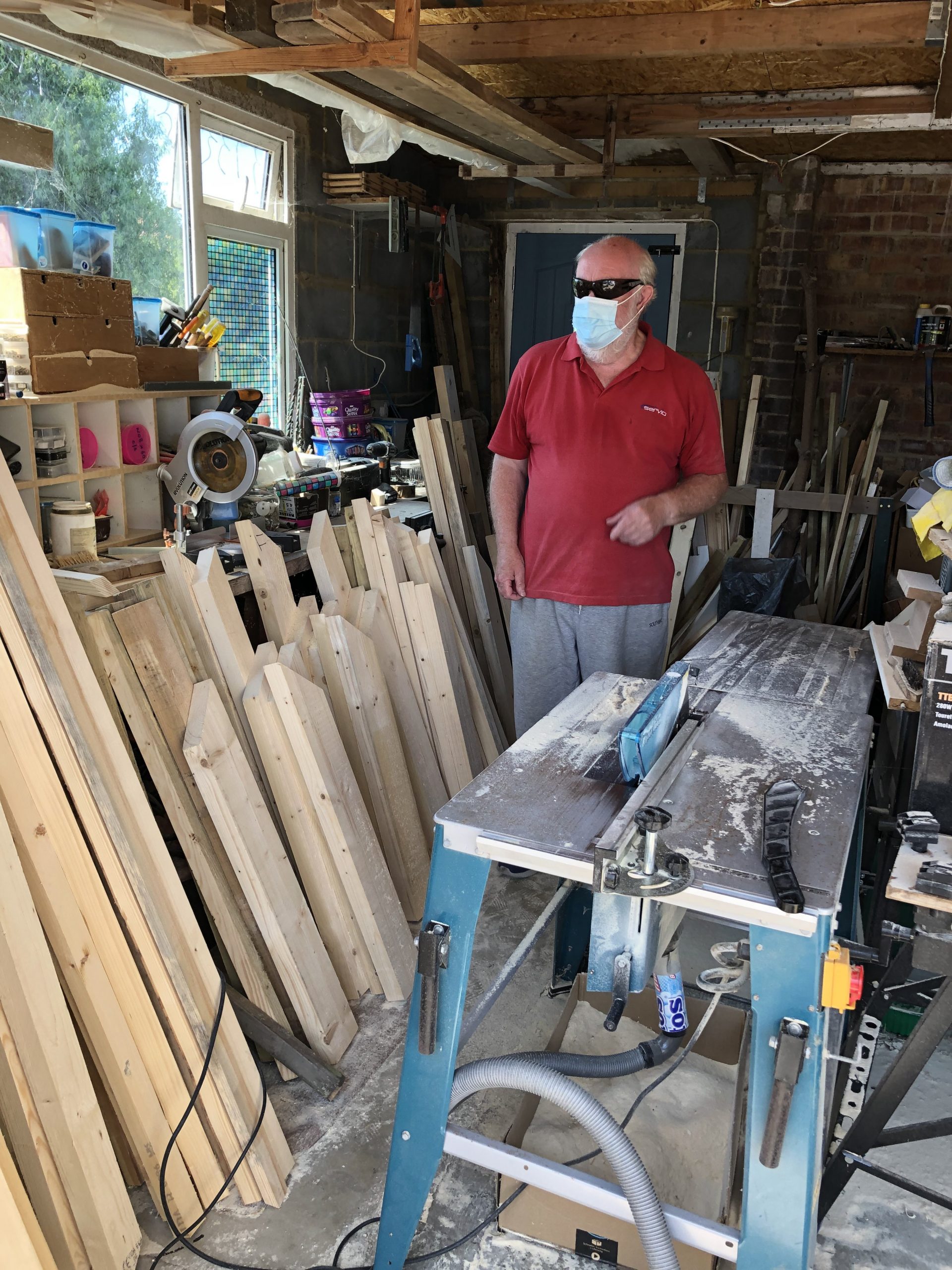 An EBS member cutting wood for torch handles